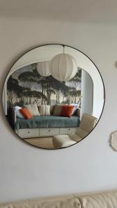espejo que refleja un sofá en la sala de estar en Massilia Calling appartement Marseille proche métro climatisé bien décoré, en Marsella