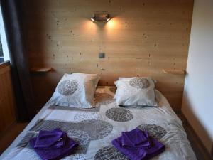 ein Schlafzimmer mit einem Bett mit lila Handtüchern darauf in der Unterkunft Appartement Châtel 4 pièces, 6 pers, balcon, proche centre - FR-1-676-117 in Châtel