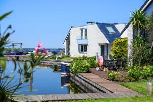 a house on the water next to a canal at Amsterdam / Loosdrecht Rien van den Broeke Village in Loosdrecht