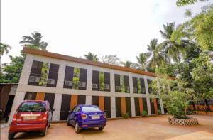 two cars parked in front of a building at HOTEL MOON LITE RESIDENCY - Marve Road Malad West in Mumbai