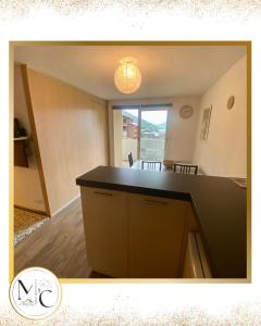a kitchen with a black counter top in a room at T2, proche pistes, piscine chauffée, hammam in Allos