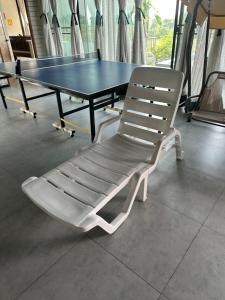a ping pong table with a white chair in front of it at Daiya Nirvana Pool Villa, Khao Yai in Klang Dong