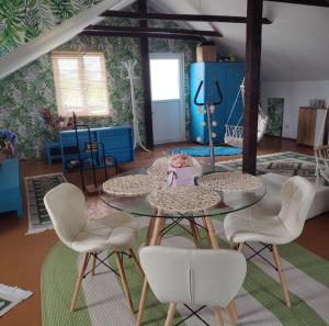 a living room with two tables and white chairs at Casa Silvia - Corbu in Corbu