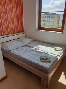 łóżko w pokoju z oknem w obiekcie Apartament Konrad w centrum 600 m od morza w Kołobrzegu