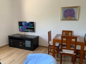 a living room with a dining room table and a television at La Barraca B - Descanso Familiar con gran patio en entorno tranquilo cerca del mar in Mojácar