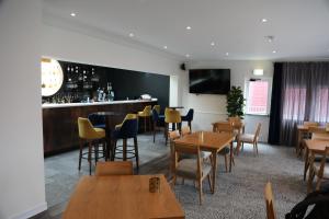 a restaurant with tables and chairs and a bar at Malvina House Hotel in Stanley