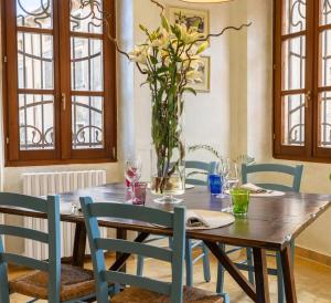 ein Holztisch mit Stühlen und eine Vase mit Blumen in der Unterkunft Locanda Moscal in Affi