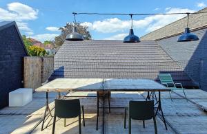 a table and chairs on a patio with two lights at Les Camuches de la fonderie - Appartements privatifs avec terrasses in Tournai