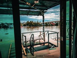 a boat on a river with a view of a bridge at Watyai GuestHouse in Samut Songkhram