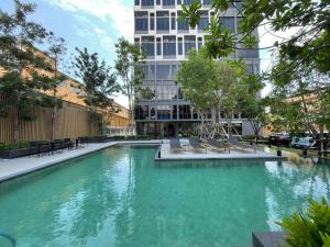 a swimming pool with chairs and a building at 2BR BTS On Nut Siamese87 Two Bedroom LOFT hight floor 24 in Bangkok