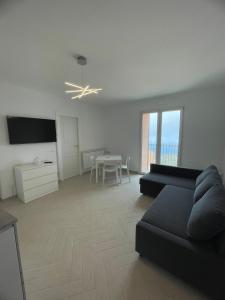 een woonkamer met een zwarte bank en een tafel bij Pollina Suites & Apartments in Pollina