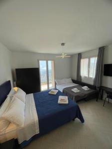 een hotelkamer met twee bedden en een bank bij Pollina Suites & Apartments in Pollina +54 foto's