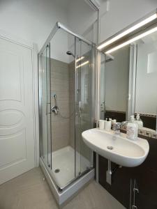 een badkamer met een glazen douche en een wastafel bij Pollina Suites & Apartments in Pollina