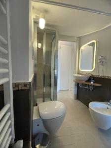 a bathroom with a toilet and two sinks and a shower at Pollina Suites & Apartments in Pollina +54 photos