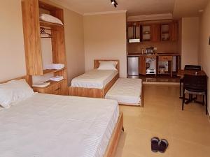 a hotel room with two beds and a kitchen at Sol Apartments Gjiri Lalzit in Durrës +33 photos