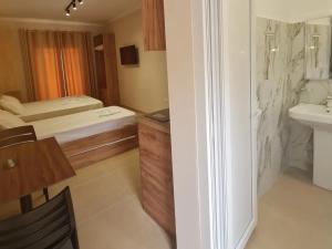 a bathroom with a bed and a sink in a room at Sol Apartments Gjiri Lalzit in Durrës