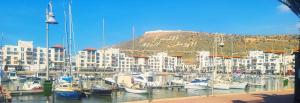 a group of boats docked in a harbor with buildings at Agadir Marina vue piscine in Agadir