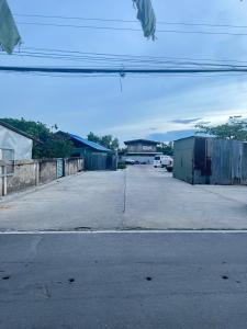 an empty street with cars parked in a parking lot at Watyai GuestHouse in Samut Songkhram