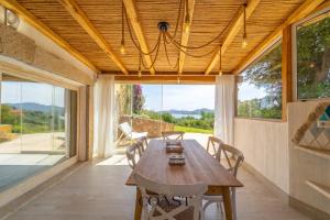 Un comedor con mesa y sillas de madera. en Appartamento Smeraldo - Con vista mare, en Olbia