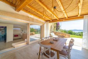 Una sala de estar con una mesa y sillas de madera. en Appartamento Smeraldo - Con vista mare, en Olbia