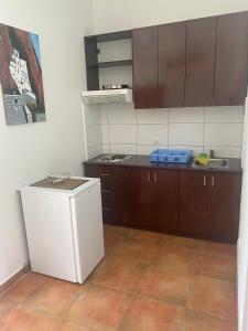a kitchen with a white refrigerator and brown cabinets at green olive 2 in Budva