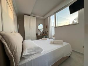 a white bed in a room with a window at St. Mary - Panoramic Suite & Terrace in Santa Maria al Bagno