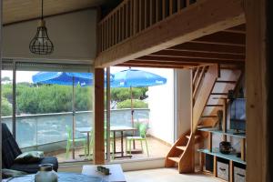 a room with a loft bed and a table with an umbrella at Bord de mer in Saint-Jean-de-Monts