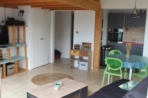 a living room with a table and a kitchen at Bord de mer in Saint-Jean-de-Monts