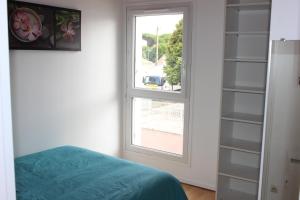 a bedroom with a window and a bed and shelves at Bord de mer in Saint-Jean-de-Monts