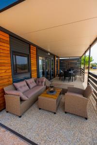 a living room with a couch and a table at Mobile Homes Pirovac with 2 shared Pools in Pirovac
