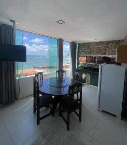 una sala da pranzo con tavolo e vista sull'oceano di FLAT MORRO Vista panorâmica 1praia a Cairu