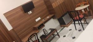 a room with a tv and two chairs and a table at Hotel Zen in Khajurāho