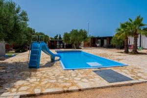 a swimming pool with a slide in a yard at Mobile Homes Pirovac with 2 shared Pools in Pirovac
