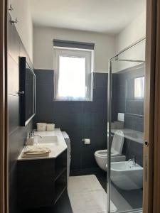 a bathroom with a sink and a toilet and a shower at M&M BERGAMO CENTER - Modern flat with FREE WIFI - Rent BIKE in Bergamo +12 photos