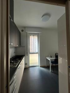a kitchen with white cabinets and a table and a window at M&M BERGAMO CENTER - Modern flat with FREE WIFI - Rent BIKE in Bergamo