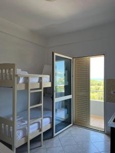 a room with bunk beds and a balcony at Apartments Rezidenca Sinani Orikum in Orikum