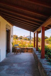 a porch of a house with a table and a bench at Just Like Home - Casa do Cruzeiro in Moledo