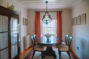 a dining room with a table and chairs and a window at Just Like Home - Casa do Cruzeiro in Moledo