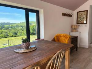a dining room with a wooden table and a large window at The Bw thyn - Ceredigion in Lampeter