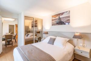 a bedroom with a large white bed and a desk at La Closerie SPA & Résidence Hôtel in Deauville
