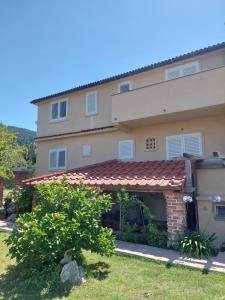 a house with a garage in front of it at Moderni apartman Tina in Mundanije