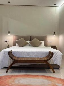 a bedroom with a large bed with a wooden bench at Nature Fruit Farm - Private Estate in Balik Pulau