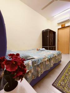 a bedroom with a bed and a vase with red flowers at Wafiy Homestay in Macang