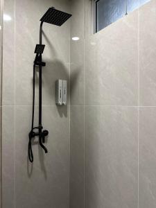 a shower with a black shower head in a bathroom at Nature Fruit Farm - Private Estate in Balik Pulau