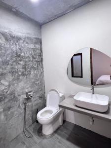 a bathroom with a sink and a toilet and a mirror at Nature Fruit Farm - Private Estate in Balik Pulau