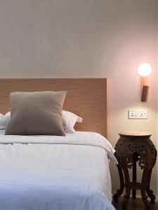 a bedroom with a bed with a wooden headboard and a table at Nature Fruit Farm - Private Estate in Balik Pulau