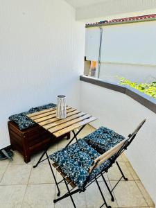 einen Tisch und zwei Stühle in einem Zimmer mit einer weißen Wand in der Unterkunft Bila lucica in Primošten