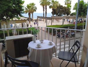 ein Tisch und Stühle auf einem Balkon mit Blick auf den Strand in der Unterkunft ALQUILER PISO BLANES con VISTAS AL MAR in Blanes + 14 Fotos