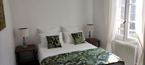 a bedroom with a bed with white sheets and pillows at Annexe du pont de la Charente Côté jardin in Châteauneuf-sur-Charente