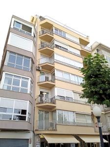 ein hohes Gebäude mit Balkonen an der Seite in der Unterkunft ALQUILER PISO BLANES con VISTAS AL MAR in Blanes